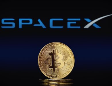 Moeda de Bitcoin à frente de logo da SpaceX