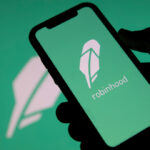 Celular com logo do aplicativo Robinhood com fundo com mesmo logo