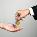 mãos trocando uma moeda de Bitcoin