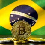 moeda de bitcoin com bandeira do brasil ao fundo (2)