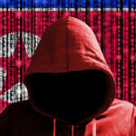 homem com capuz à frente da bandeira coreia do norte