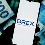 Tela de celular mostra logotipo Drex- no fundo notas de cem reais